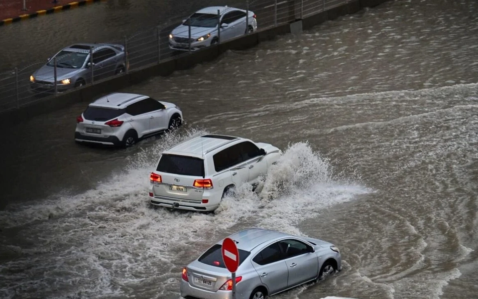 An image showing rain and flooding impacting car insurance—flooded streets, submerged cars, hydroplaning, higher claim risk.