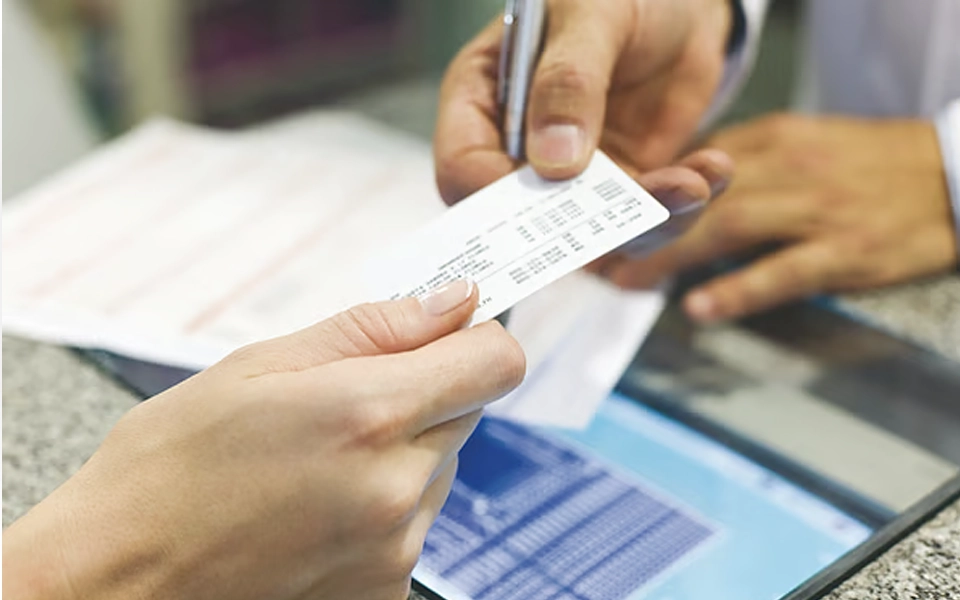 تُظهر الصورة أحد المتخصصين في الرعاية الصحية يشرح أهمية بطاقة الصحة المهنية أثناء الفحص الطبي في دبي.