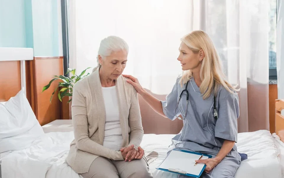 The image shows a doctor comforting a patient while illustrating the fines for not having health insurance in Dubai.